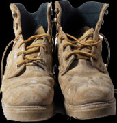 Large used work boots on a porch